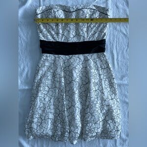 Speechless. White floral lace strapless short dress with black accents.